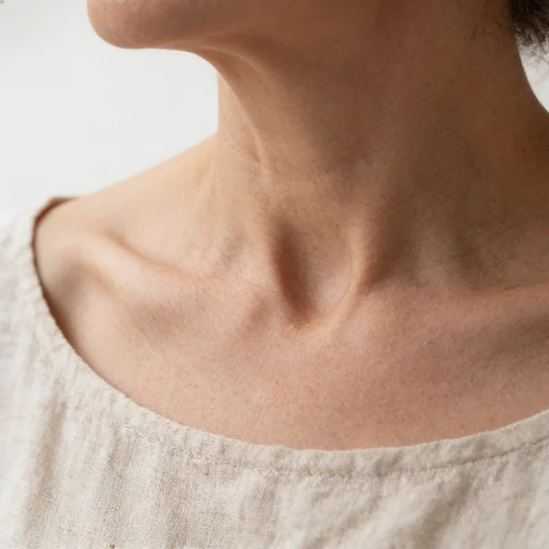 Collarbone and the base of the neck above a linen neckline.