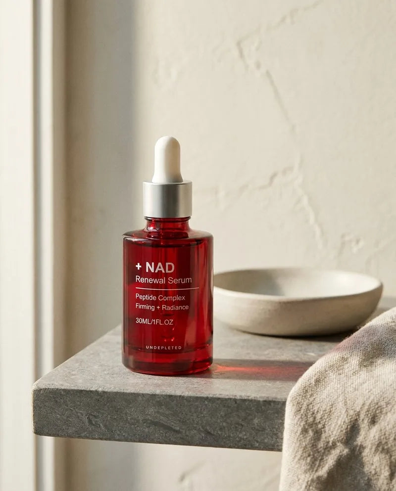 The serum bottle on a pale stone shelf in daylight.